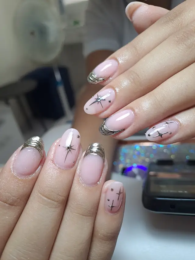 Nail art delicado con dijes en forma de estrella
