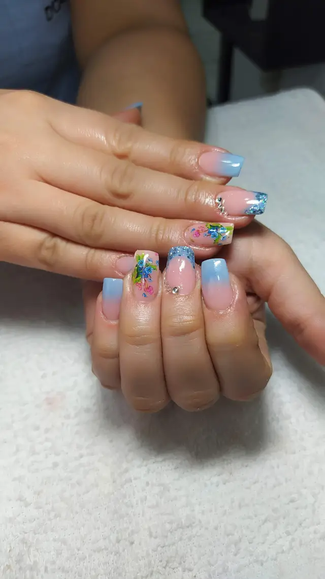 Uñas acrílicas con diseño floral azul y rosado