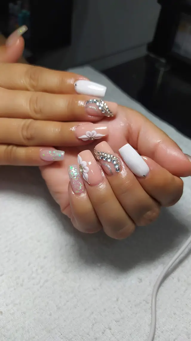 Uñas blancas con flor y brillantes decorativos